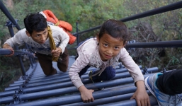 Học sinh tiểu học leo thang dựng đứng trên vách đá đến trường